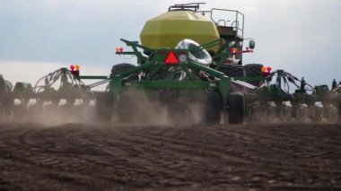 Özel büyük ekipmanlar kullanarak tarlaları tahıl ürünleriyle ekme işlemi. Kavram: Tarım.