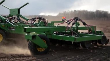 Özel tarım makineleri tarlayı sürüyor ve tohum ekiyor. Traktör sahada çalışıyor. Kavram: Tarım ve ekimin başlangıcı.