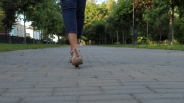 Sandalet içinde ayaklar kaldırıma yakın bir modelle basar..