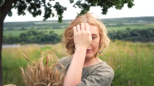 Retrato de una chica hippie rubia con espigas de trigo en las manos — Vídeo de stock