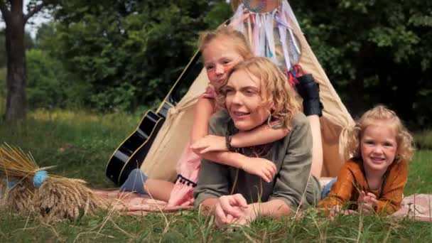 Dos hijas rubias hippies abrazan a su madre firmemente. — Vídeo de stock