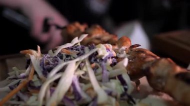 Erkek eller domuz kebabına sebze ekler. Şef restoranda doyurucu bir öğle yemeği hazırlıyor. Geleneksel Kafkas yemeği. 