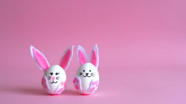 Pembe arka planda yumurtadan yapılmış Paskalya tavşanları.. 