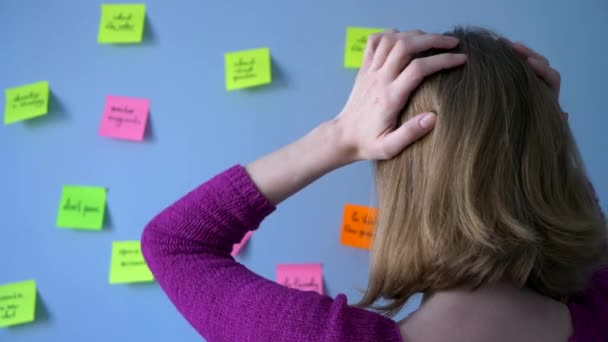 Mujer Rubia Toma Cabeza Con Las Manos Contra Telón Fondo — Vídeos de Stock