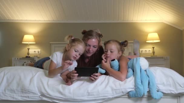 Familj Flickor Tittar Karikatyrer Surfplattan Som Ligger Sängen Sovrummet Mamma — Stockvideo