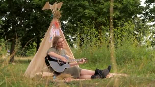 Hippie Menina Vestido Verde Botas Pretas Toca Guitarra Preta Sentado — Vídeo de Stock