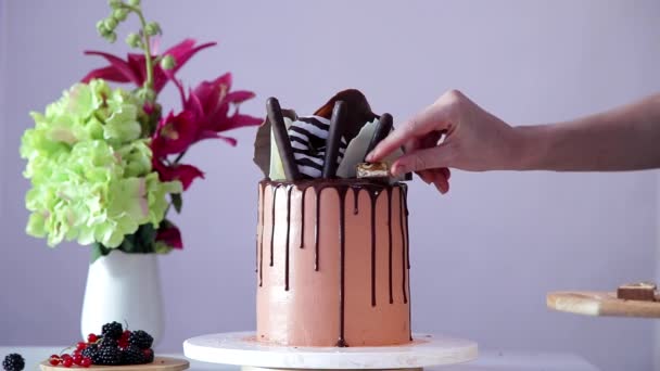 Proces van het versieren van verjaardagstaart met stukjes chocolade. — Stockvideo