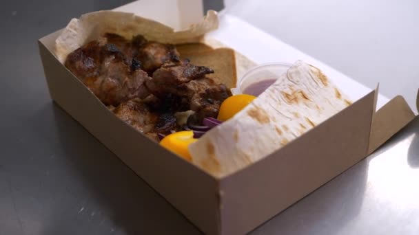 Delicious kebab with sauce and vegetables in the delivery box. — Stock video