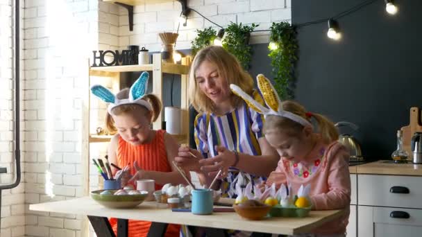 Famiglia felice sta dipingendo uova di Pasqua mentre si siede a tavola. — Video Stock