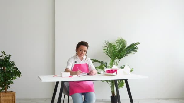 Pige wienerbrød kok placerer en ordre til levering af cupcakes i kontoret – Stock-video