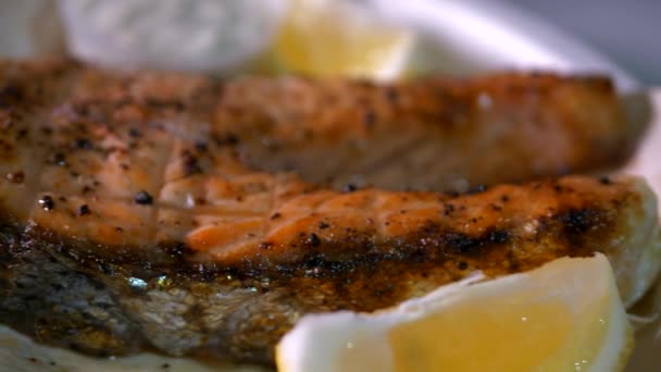 レモンとソースのクローズアップで魚のステーキを食欲をそそります — ストック動画