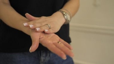 Kadın elleri kremi ovuyor. Kız ellerinin narin cildine jöle sürer. Hazırlık elleri işten önce