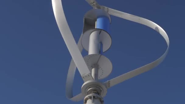 Ostrza turbiny wiatrowej obracają się w tle niebieskiego nieba zbliżenie — Wideo stockowe