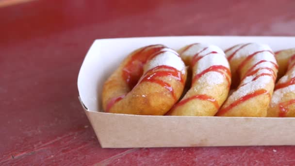 Conjunto de rosquinhas com açúcar em pó e cobertura de morango em caixa de papel — Vídeo de Stock