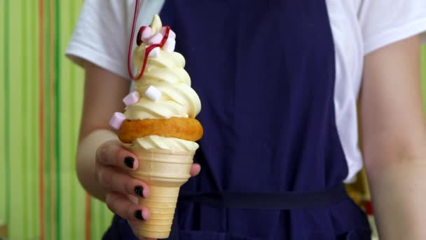 La cobertura de fresa se vierte lentamente sobre el helado en un cono de gofre — Vídeos de Stock