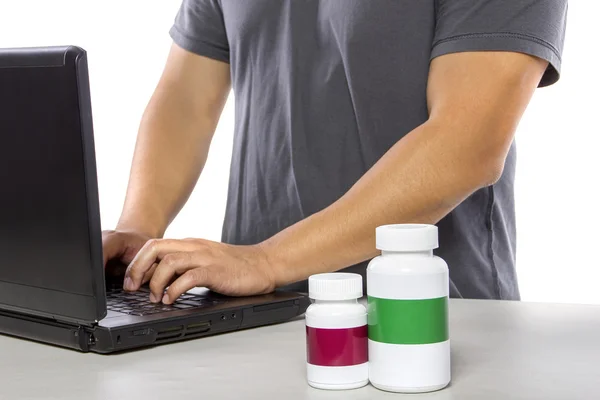 Man using laptop to ordering supplements — Zdjęcie stockowe