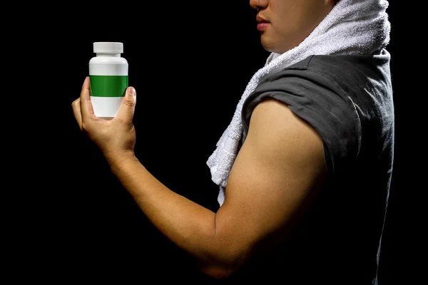Male with bottle of energy booster supplement — Stock fotografie