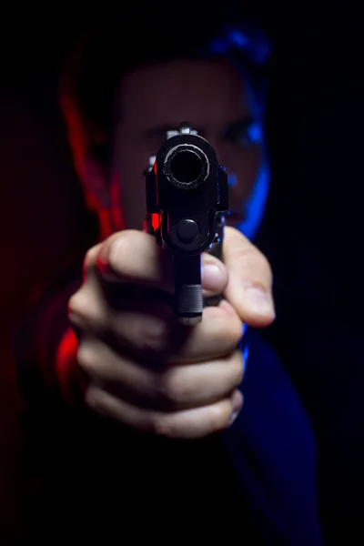 Oficial segurando uma arma — Fotografia de Stock