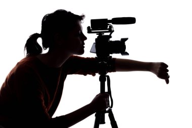 Bir kadın bağımsız film yapımcısının silueti, çevrimiçi içerik yaratıcısı veya kamera ile oyuncu seçimi yönetmeni ve mikrofon yerleştirme stresi