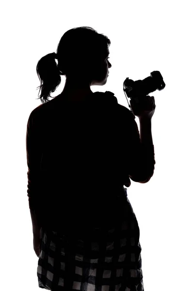 一个女摄影师徒步旅行的背光轮廓 在白色背景下被隔离成复合材料 她拿着相机 装扮成记者或业余爱好者 — 图库照片