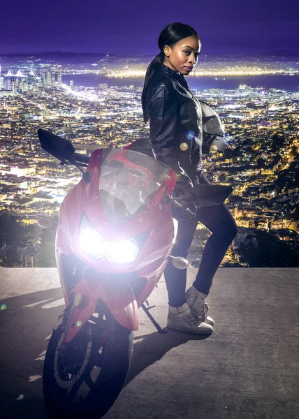 美しいサンフランシスコの街並みの景色の上にオートバイで夜の道路に革のジャケットとヘルメットを身に着けているスポーティ女性オートバイやバイカー — ストック写真