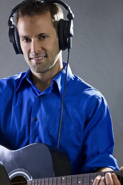 Male singer holding a guitar — Stock Photo, Image