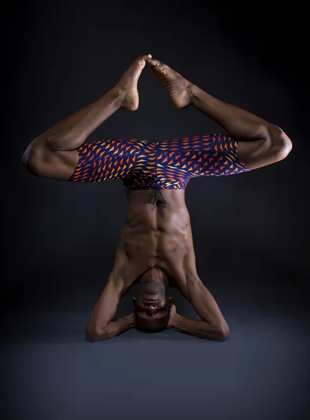 Black man doing upside down yoga — Stock Photo, Image