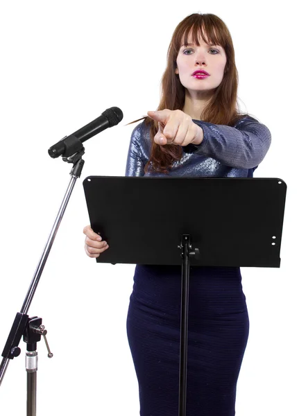 Girl speaking into a microphone and gesturing — Stock Photo, Image