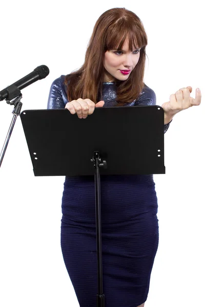 Menina falando em um microfone e gesticulando — Fotografia de Stock