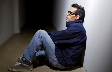 Depressed man in dark hallway clipart