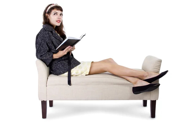 Girl on chaise lounge reading book — Stock Photo, Image