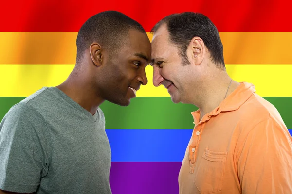 Homosexual couple with a rainbow gay pride flag — Stockfoto