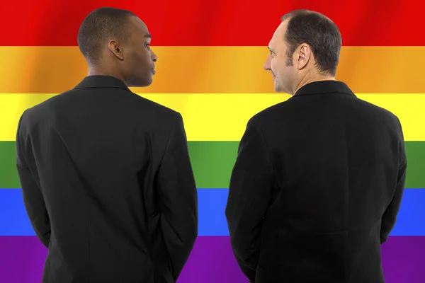 Homosexual couple with a rainbow gay pride flag — Stock Photo, Image