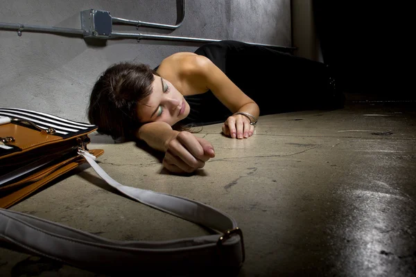 Female crime victim lying on the street floor Stock Photo