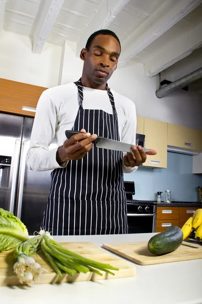 man wearing an apron and cooking at home