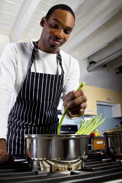 Homme portant un tablier et cuisinant à la maison — Photo