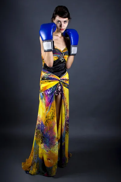 Mulher de vestido usando luvas de boxe — Fotografia de Stock