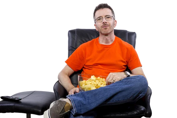 Homme regarder la télévision et manger des chips — Photo