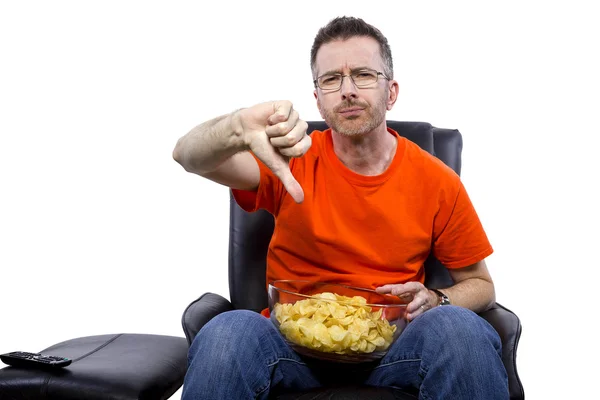 Człowiek, oglądanie telewizji i jedzenie frytek — Zdjęcie stockowe