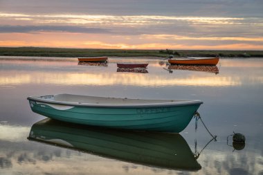 Deniz suyunun üzerinde huzurlu günbatımında güzel küçük tekneler.