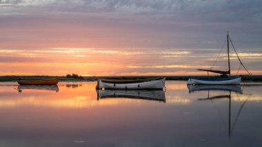 Deniz suyunun üzerinde huzurlu günbatımında güzel küçük tekneler.