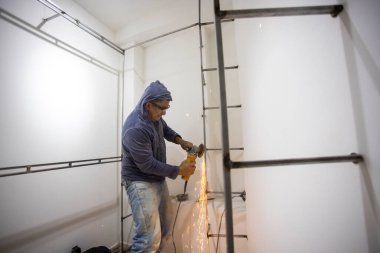 Kolombiyalı metal marangoz soyunma odasında metal parlatıyor.