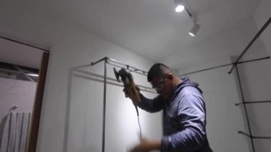 Kolombiyalı metal marangoz soyunma odasında metal parlatıyor.