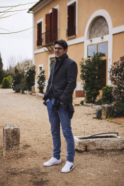 Genç adam evinin önünde bekliyor.