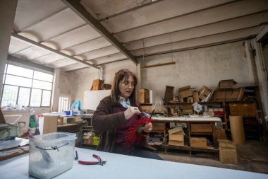 İspanyol kadın bir el fan tasarım atölyesinde çalışıyor.