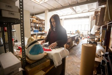 İspanyol kadın bir el fan tasarım atölyesinde çalışıyor.