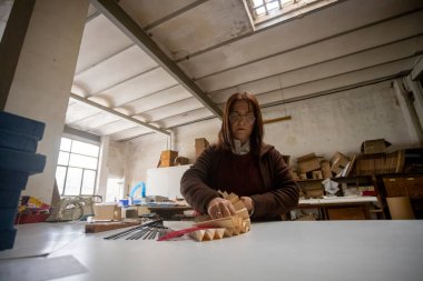 İspanyol kadın bir el fan tasarım atölyesinde çalışıyor.