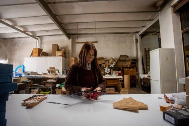 İspanyol kadın bir el fan tasarım atölyesinde çalışıyor.