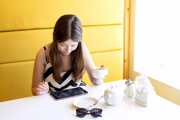 Beautiful young brunette woman in a room cafe