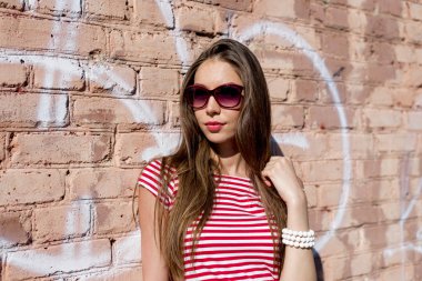 Güzel genç kadın, açık havada, parlak kırmızı t-shirt, moda tarzı dinlenme